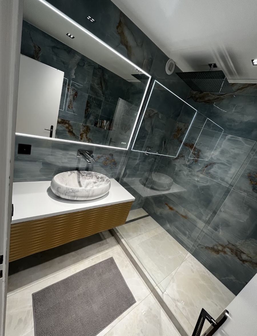 Salle de bain effet onyx bleu avec vasque à poser et miroir lumineux
