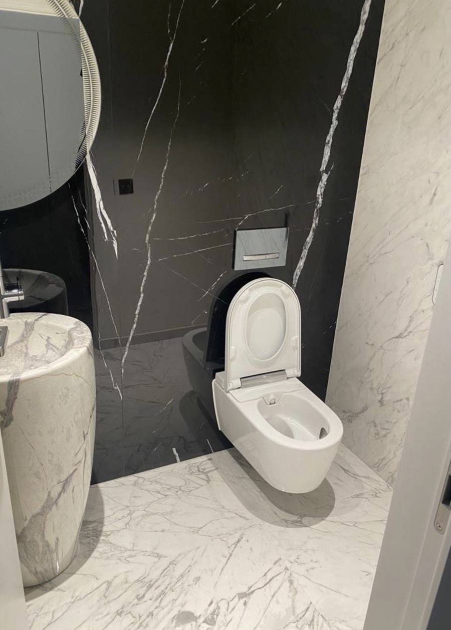 WC suspendu sur mur en marbre noir avec lavabo colonne en marbre blanc